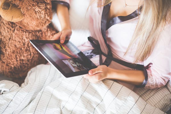 Girl Holding an iPad in Bed